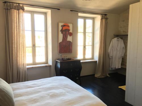 阿尔桑雷Les Clés d'Ars的卧室配有一张床和一幅画作