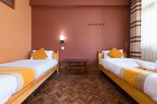 加德满都Khangsar Home的酒店客房设有两张床和一张桌子。