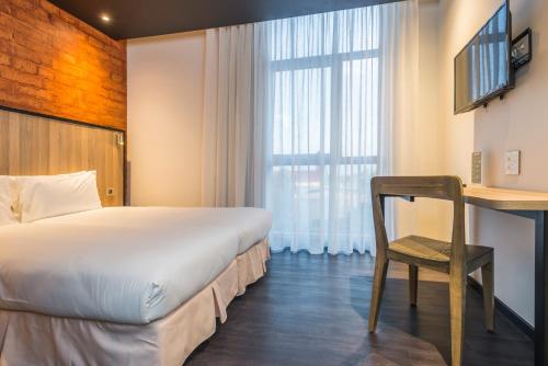 德班德班奥诺莫酒店的酒店客房配有一张床、一张桌子和一把椅子。