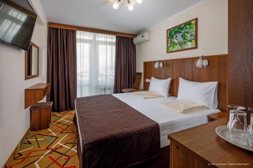 格连吉克Privetlivy bereg的酒店客房配有一张床铺和一张桌子。