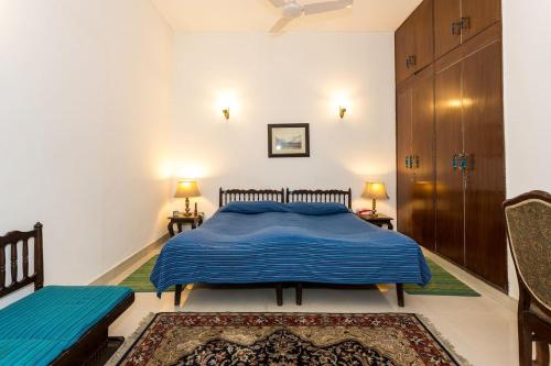 新德里Eleven Bed & Breakfast的一间卧室配有蓝色的床和两把椅子