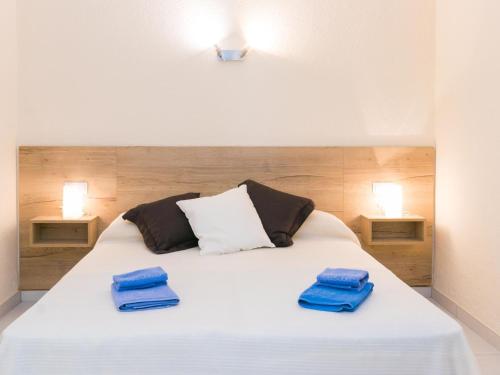 罗萨斯Apartment Velazquez-3 by Interhome的卧室配有白色床和蓝色毛巾