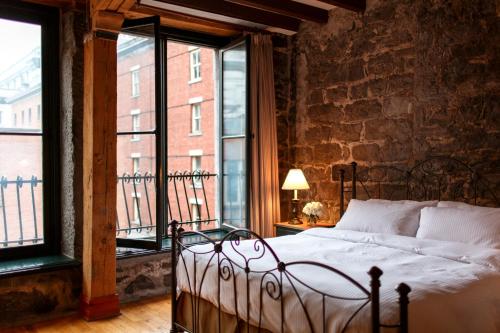 蒙特利尔Auberge du Vieux Port by Gray Collection的一间卧室设有一张床和一个大窗户