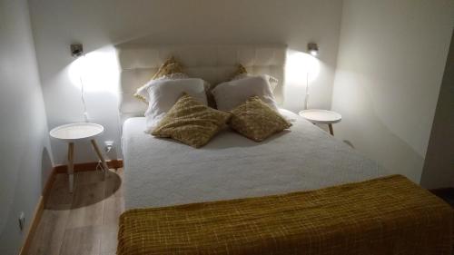 坎普自由鎮Casa da Corisca的一间卧室配有带枕头的床铺和两张桌子