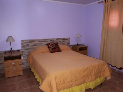 马拉圭Departamentos San Expedito的一间卧室设有一张床和砖墙