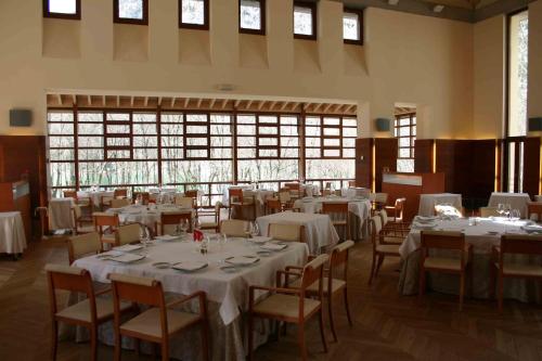 潘蒂科萨格兰酒店 - 巴尔尼里奥德潘蒂科萨的一间设有白色桌椅和窗户的用餐室