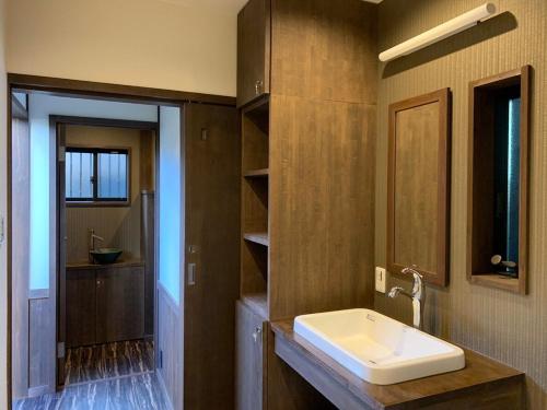近江八幡市近江の町家 門的一间带水槽和镜子的浴室