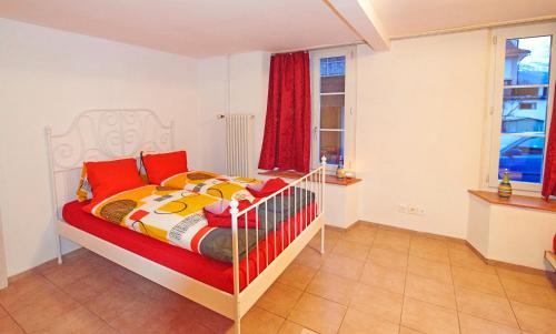 UnterseenSunny Day Holiday Apartment的一间卧室配有一张带红色和黄色毯子的床