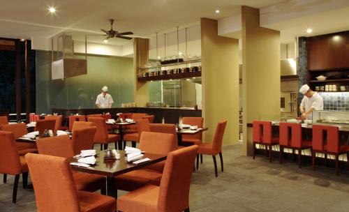 金马仑高原Cameron Highlands Resort - Small Luxury Hotels of the World的餐厅设有桌椅,厨房设有厨师