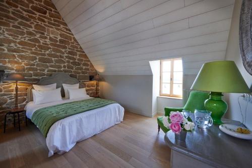 勒孔凯莱加莱白朗度假屋酒店的一间卧室配有一张床和一张带绿灯的桌子