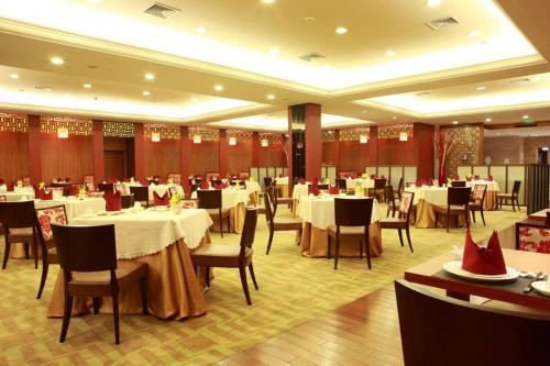 上海神旺大酒店的用餐室配有白色桌椅和桌子。