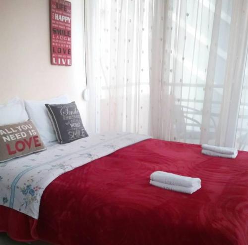 亚历山德鲁波利斯Nice & Quiet Apartment in Best Area的一间卧室配有红色的床和2条毛巾