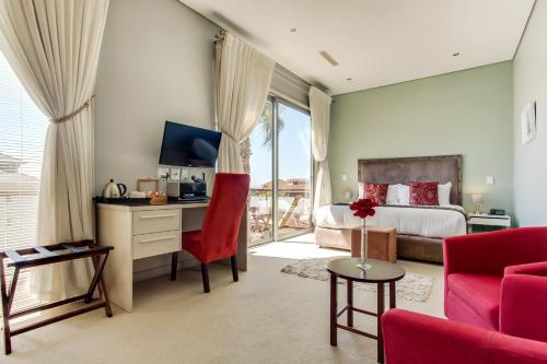 开普敦The One 8 Hotel的一间卧室配有一张床和一张书桌及电视