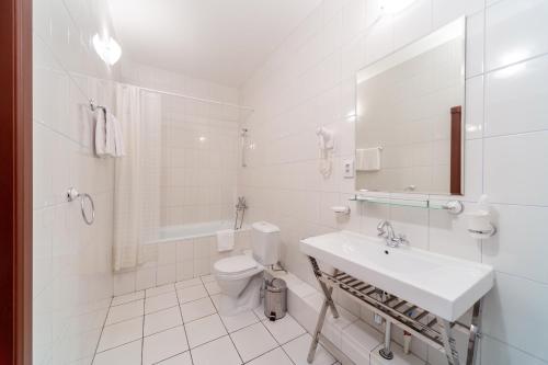 萨马拉绅士酒店的白色的浴室设有水槽和卫生间。