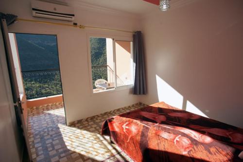 Tagherat AnekrimAuberge BAB IMOUZER的一间卧室设有一张床和一个大窗户