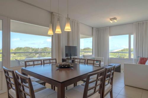 瓦勒里亚德玛瓦莱里娅海滩公寓的一间带桌椅和电视的用餐室