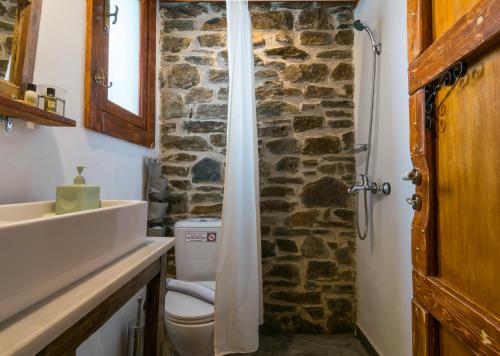 TriovasálosMilos Dream Life的一间带卫生间和石墙的浴室