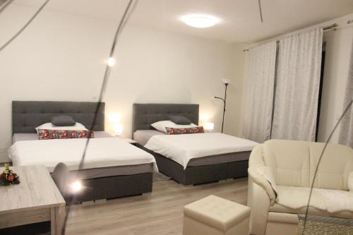 布拉格Element Prag Airport Apartment的一间卧室配有两张床、一张沙发和一把椅子