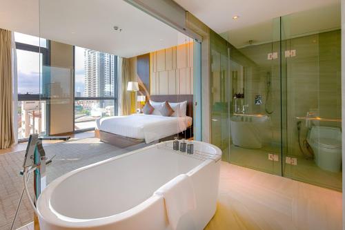 岘港岘港新东方酒店的带浴缸、床和浴缸的大浴室