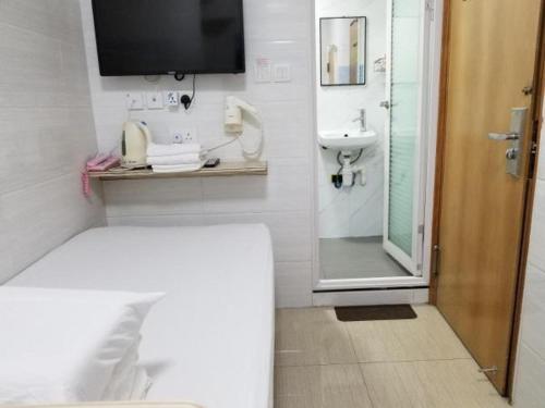 香港亚洲旅游宾馆的一间带床、水槽和淋浴的浴室