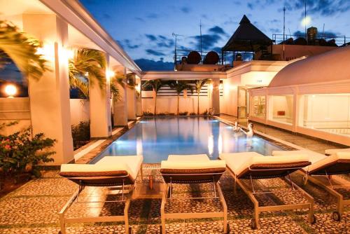 芽庄Rembrandt Hotel Nha Trang的一个带躺椅的游泳池以及一座房子