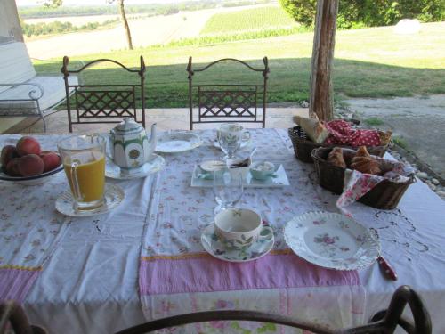 利勒茹尔丹卢贝乐住宿加早餐旅馆的桌子上放着食物和杯子,盘子