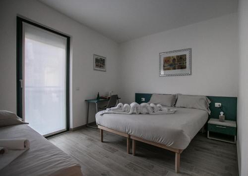 蒂拉诺B & B Il sorriso的一间卧室设有一张大床和一个大窗户