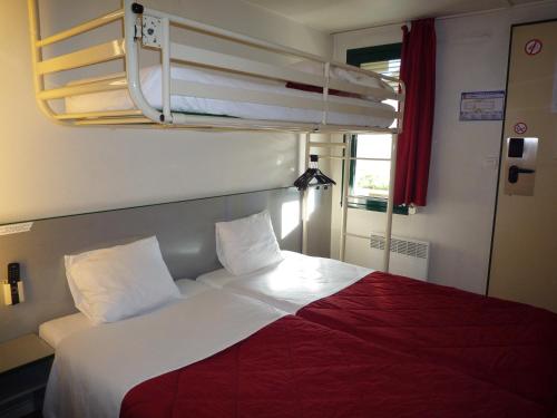瓦朗斯南瓦朗斯普瑞米尔经典酒店的宿舍间的一张床位,配有两张双层床