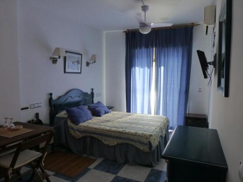 圣何塞波多黎各赫诺韦斯旅馆的一间卧室配有一张床、一张书桌和一个窗户。