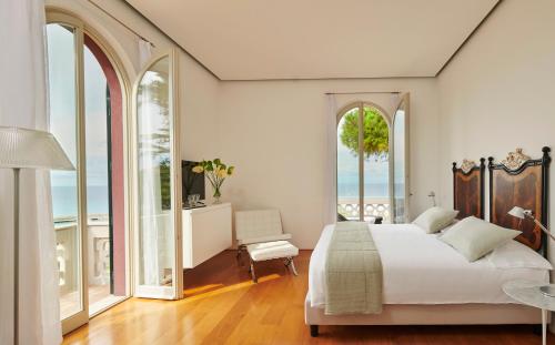 特罗佩阿保拉别墅酒店的一间卧室设有一张大床和大窗户