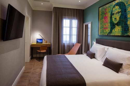 佛罗伦萨The Frame Hotel的酒店客房设有一张大床和一张书桌。