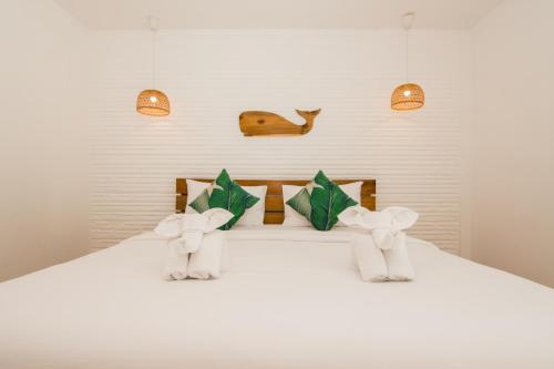 奥南海滩Whalecome Aonang Resort-SHA Extra Plus的一张白色的床,上面有两只填充的动物