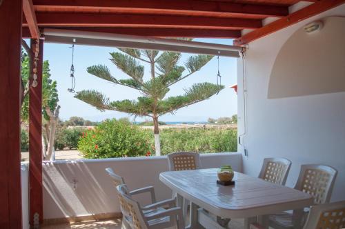 纳克索斯岛卡斯特拉基Felicia's sun-side house的棕榈树阳台的桌椅