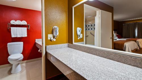 卡马里奥SureStay Hotel by Best Western Camarillo的一间带卫生间的浴室和一间带床的房间