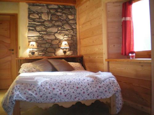 Verrayes奥库尔旅馆的一间卧室配有一张石墙床