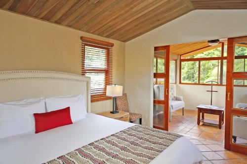 下博克特Los Establos Boutique Resort - All Inclusive的卧室配有一张大白色床和红色枕头