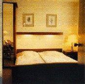 海滨诺德韦克阿德米拉尔酒店的一间卧室配有一张带木制床头板的床