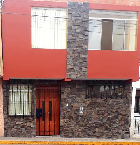塔克纳El Marquez的一座红色的建筑,有石墙和门