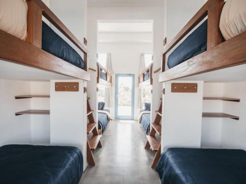 坎古Kos One Hostel的一间设有两张床的房间和一个带架子的走廊