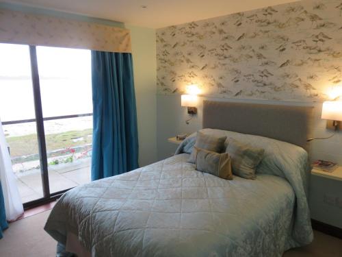 阿尔弗斯顿海湾骑兵酒店&餐厅的一间卧室设有一张大床和一个窗户。
