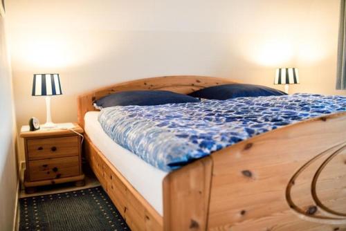 胡苏姆Bulemanns Haus的一间卧室配有一张木床和一个带两盏灯的床头柜。