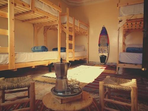 依索安Imsouane soul lodge的客房设有两张双层床和一张桌椅。