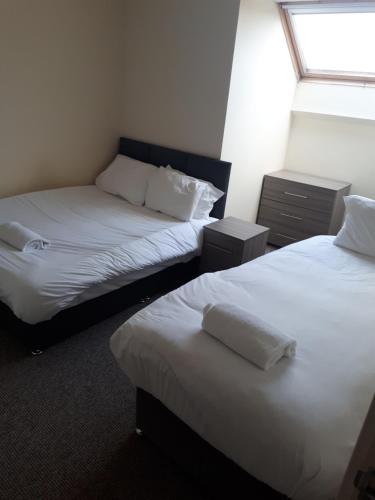 IfieldMarvellous Meridian Maisonette的配有白色床单和窗户的客房内的两张床