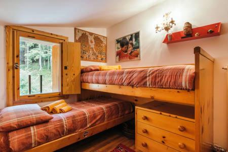 摩德纳迪-坎皮格里奥CENTRAL WOODEN CHALET WITH FOREST VIEW的一间卧室设有两张双层床和一扇窗户。