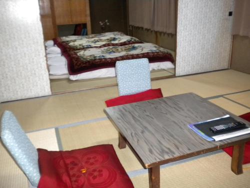 旭川米玛特苏索旅馆的配有桌椅和床的房间