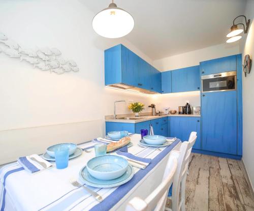 博尼法乔Faro della Madonetta的厨房配有蓝色橱柜和蓝色餐具桌
