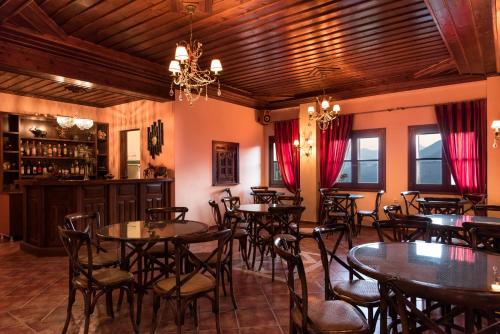 埃拉蒂特里卡隆克鲁皮酒店的一间带桌椅的餐厅和一间酒吧
