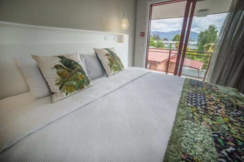 蒂阿瑙红草丛汽车旅馆的卧室配有一张大白色床和窗户
