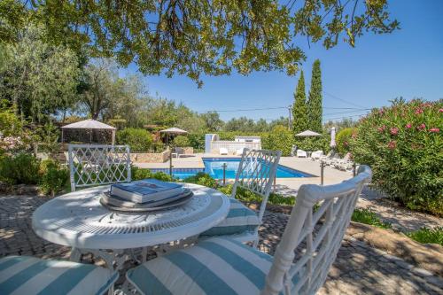 阿尔曼萨Farm of Dreams Algarve的游泳池前的桌椅
