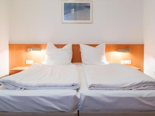 岑平Apartment Fridolin的配有2张床的带白色床单和枕头的客房